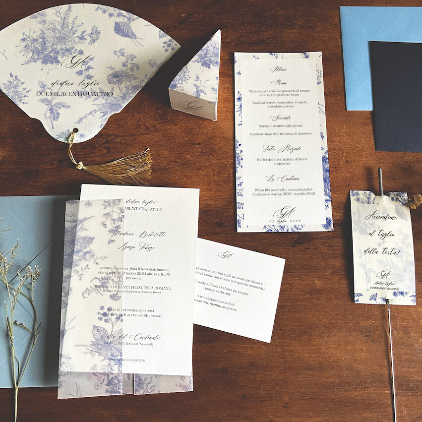 wedding stationery, coordinato grafico di matrimonio nei toni del blu e carta da zucchero a tema toile de jouy, invito, cono riso, ventaglio, scintille luminose, partecipazione di nozze