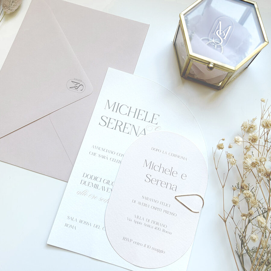 partecipazione di matrimonio sagomata nei toni del rosa cipria e grigio con cofanetto per fedi personalizzato con logo sposi